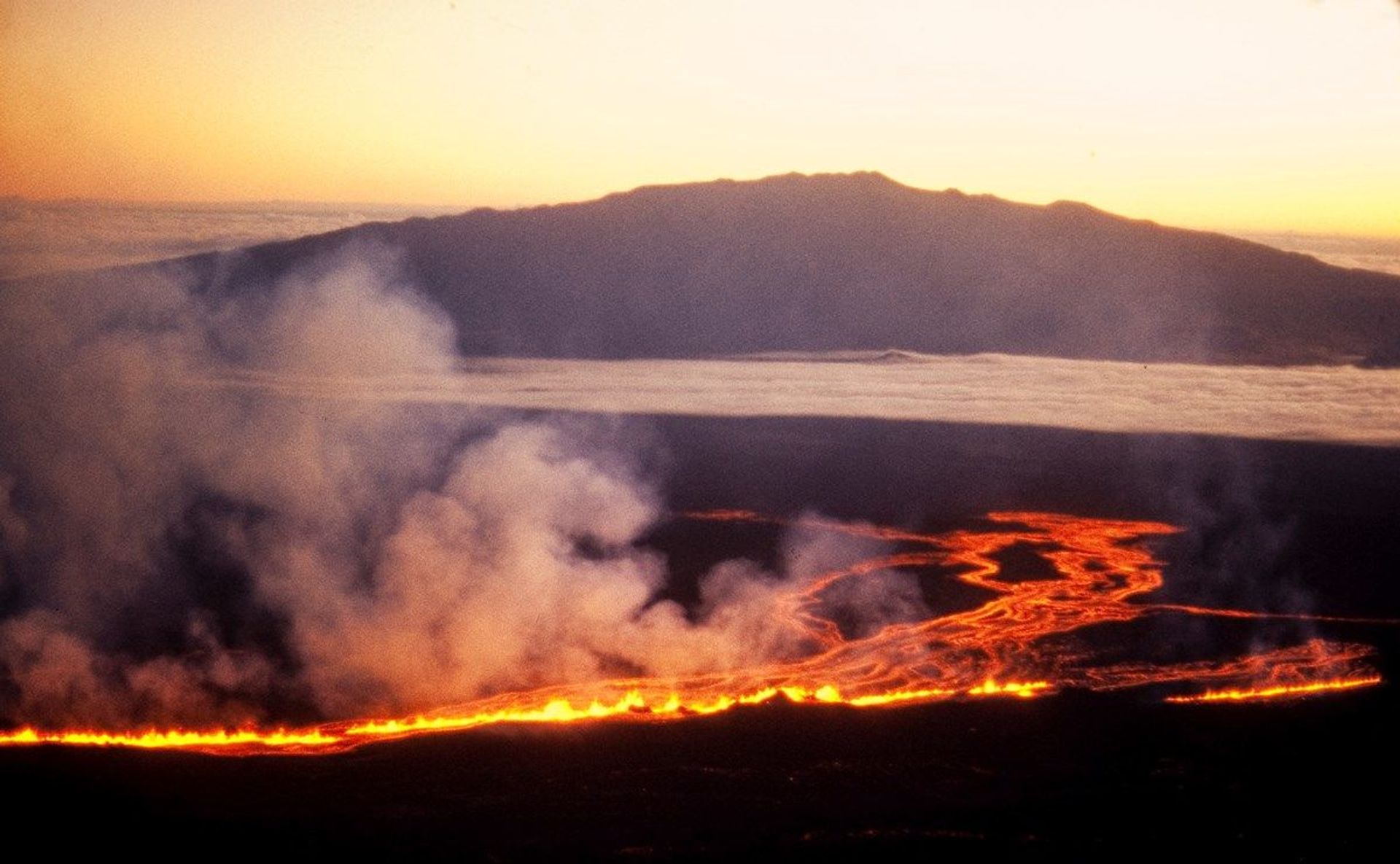 The sun rises beyond Mauna Kea as lava flows down the side of Mauna Loa on the morning of July 6th, 1975 The sun rises beyond Mauna Kea as lava flows down the side of Mauna Loa on the morning of July 6th, 1975 - Sputnik International, 1920, 21.08.2022