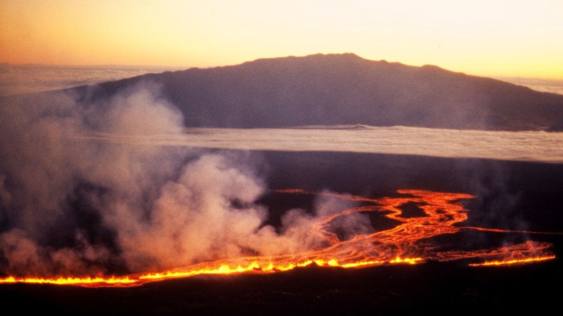 The sun rises beyond Mauna Kea as lava flows down the side of Mauna Loa on the morning of July 6th, 1975 The sun rises beyond Mauna Kea as lava flows down the side of Mauna Loa on the morning of July 6th, 1975 - Sputnik International, 1920, 13.03.2021
