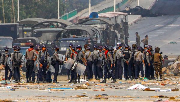 Police stand near makeshift barricades set up by protesters during a crackdown on demonstrations against the military coup in Hlaing Tharyar township in Yangon on March 14, 2021.  - Sputnik International