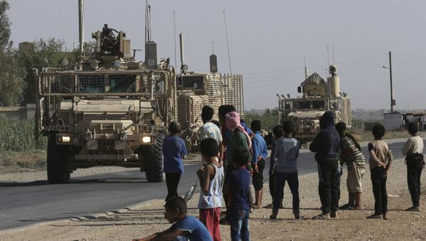  In this July 26, 2017 file photo, Syrian children and youths gather on a street as they look at a U.S. armored vehicle convoy pass on a road that links to Raqqa, northeast Syria. - Sputnik International