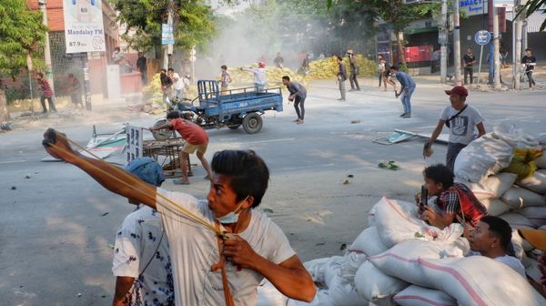 A man uses a slingshot during the security force crack down on anti-coup protesters in Mandalay, Myanmar - Sputnik International