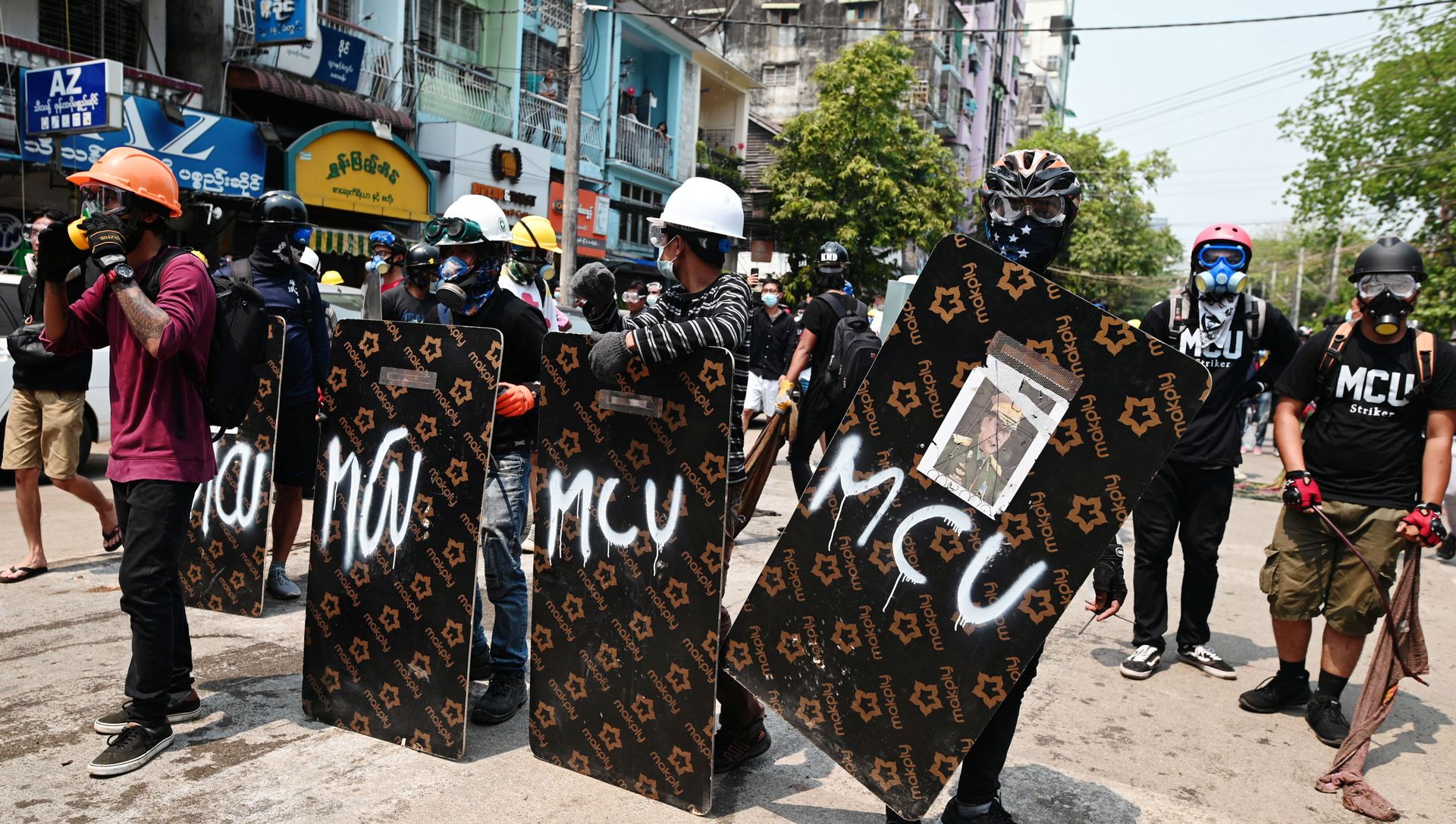 Demonstrators stand behind makeshift shields during an anti-coup protest in Yangon Demonstrators stand behind makeshift shields during an anti-coup protest in Yangon - Sputnik International, 1920, 29.03.2021