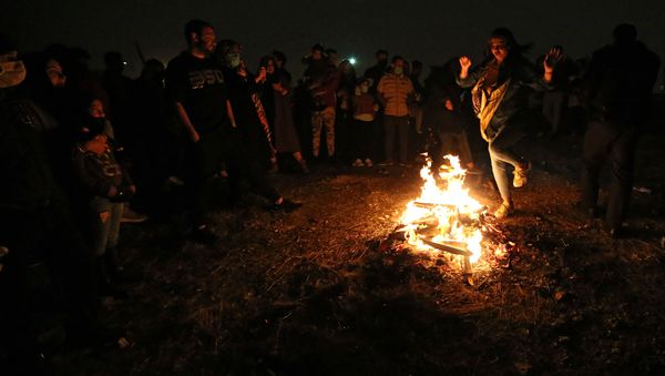 An Iranian jumps over the bonfire in Tehran on March 16, 2021 during the Wednesday Fire feast, or Chaharshanbeh Soori, held annually on the last Wednesday eve before the Spring holiday of Noruz. - Sputnik International