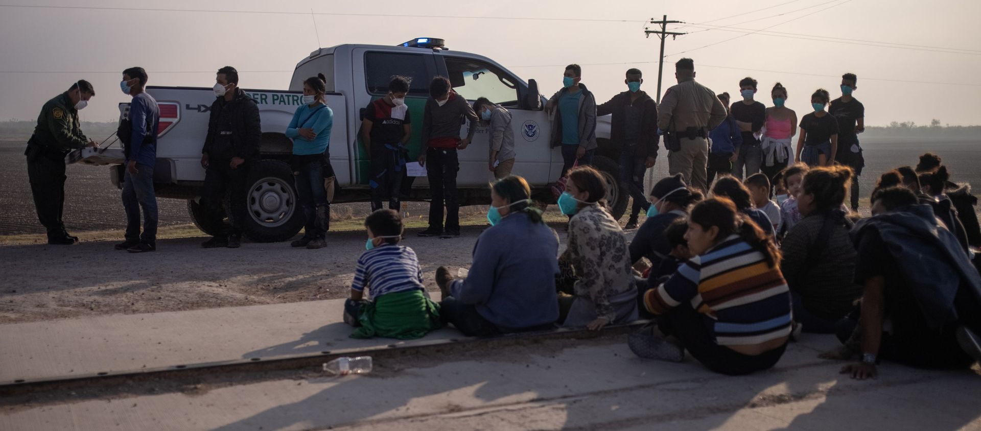 A U.S. Border Patrol agent processes asylum-seeking unaccompanied minors as family units sit on the sideline after about 70 migrants crossed the Rio Grande river into the United States from Mexico on a raft in Penitas, Texas, U.S., March 17, 2021. A U.S. Border Patrol agent processes asylum-seeking unaccompanied minors as family units sit on the sideline after about 70 migrants crossed the Rio Grande river into the United States from Mexico on a raft in Penitas, Texas, U.S., March 17, 2021. - Sputnik International, 1920, 22.03.2021