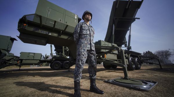 A member of Japan Ground Self-Defense Force stands guard next to a surface-to-air Patriot Advanced Capability-3 (PAC-3) missile interceptor launcher vehicle - Sputnik International