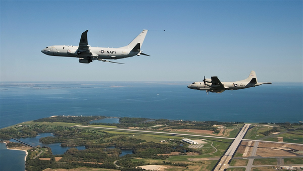 The first P-8A Poseidon test aircraft, followed by its propeller-driven P-3C predecessor, flies past NAS Patuxent River. File photo. - Sputnik International
