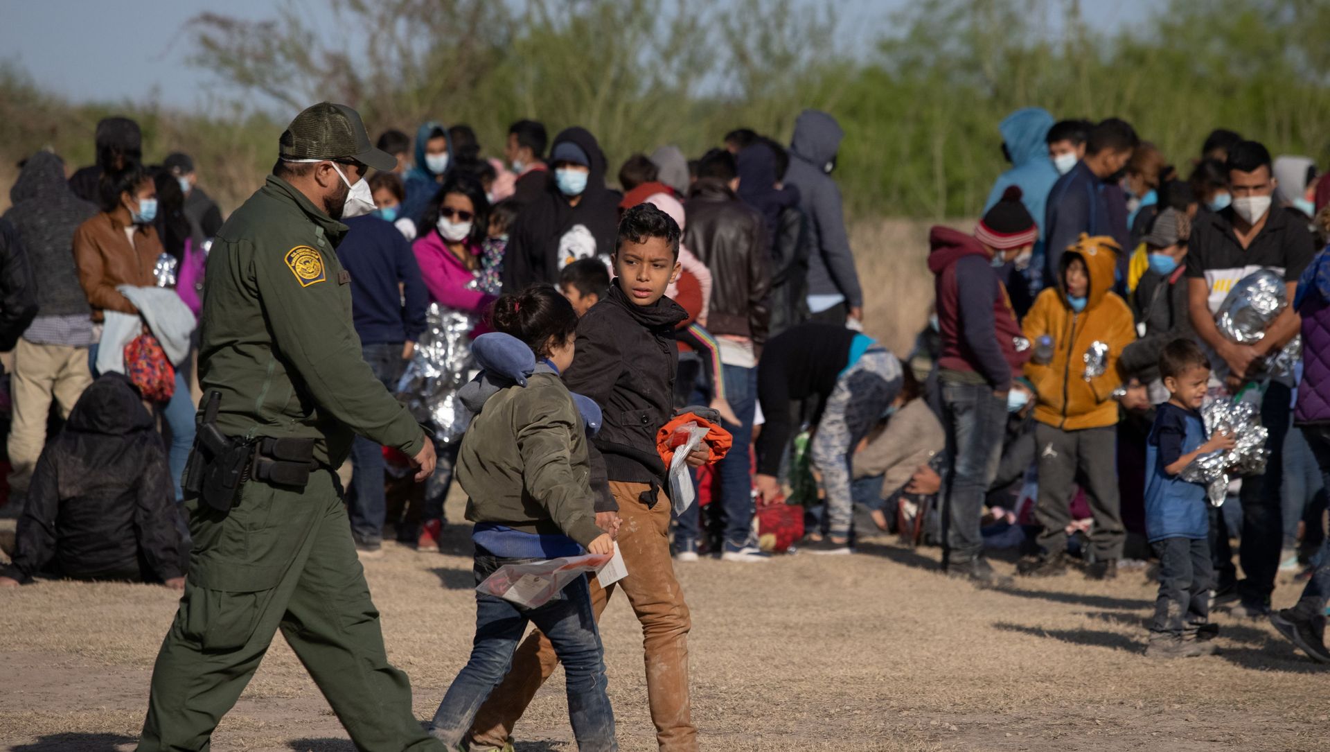 A U.S. Border Patrol Agent escorts two asylum-seeking unaccompanied minors from Central America as others take refuge near a baseball field after crossing the Rio Grande river into the United States from Mexico on rafts, in La Joya, Texas, U.S., March 19, 2021. A U.S. Border Patrol Agent escorts two asylum-seeking unaccompanied minors from Central America as others take refuge near a baseball field after crossing the Rio Grande river into the United States from Mexico on rafts, in La Joya, Texas, U.S., March 19, 2021. - Sputnik International, 1920, 21.03.2021