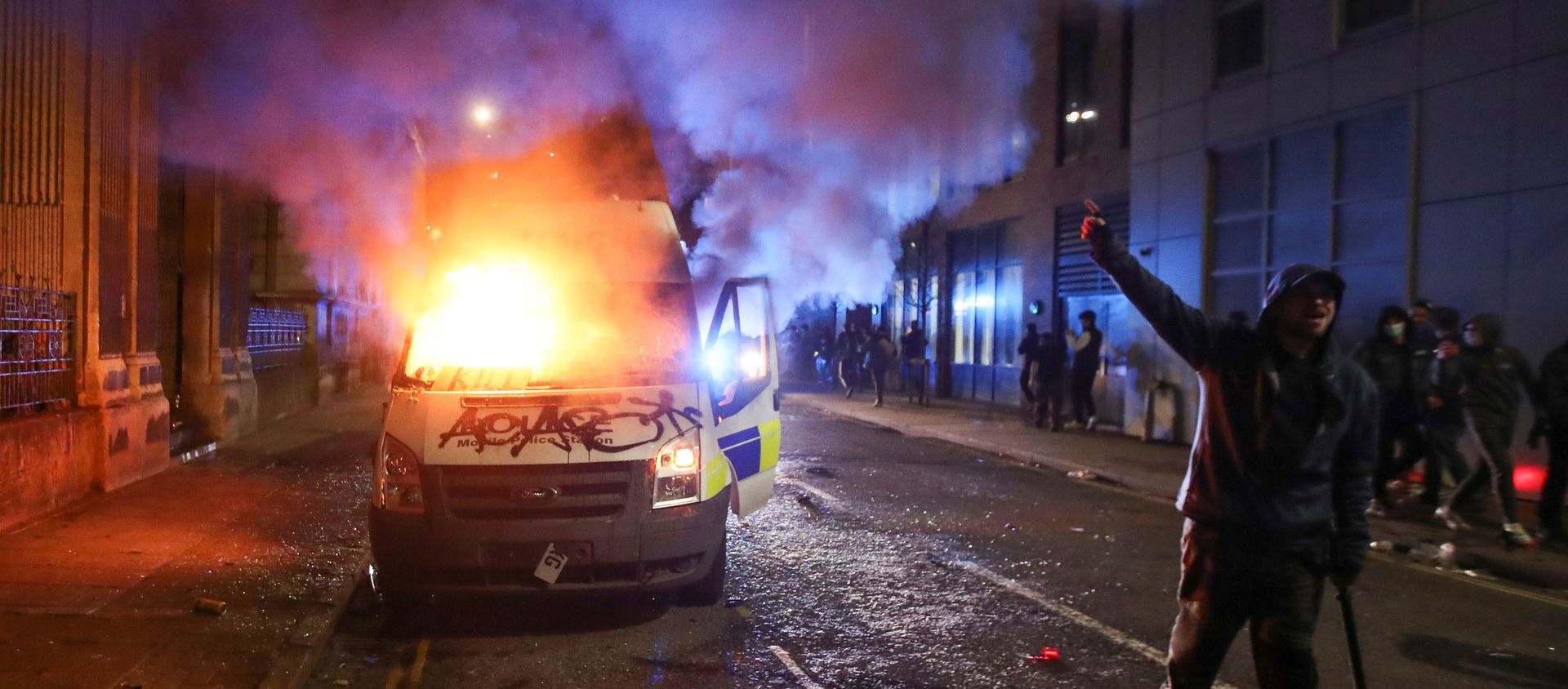 A demonstrator gestures near a burning police vehicle during a protest against a new proposed policing bill, in Bristol, Britain, March 21, 2021. - Sputnik International, 1920, 22.03.2021