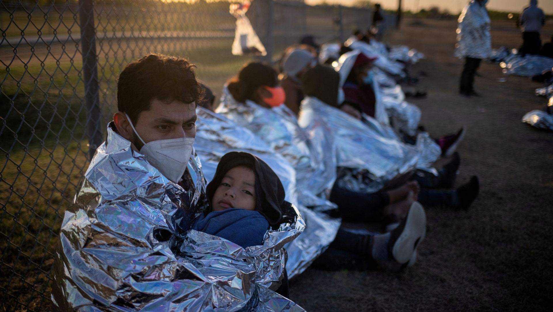 Dustin, an asylum-seeking migrant from Honduras, holds his six-year-old son Jerrardo, 6, as they awake at sunrise next to others who took refuge near a baseball field after crossing the Rio Grande river into the United States from Mexico on rafts, in La Joya, Texas, U.S., March 19, 2021. Emergency blankets were provided to the group of about 150 migrants from Central America by the U.S. Border Patrol agents. Dustin, an asylum-seeking migrant from Honduras, holds his six-year-old son Jerrardo, 6, as they awake at sunrise next to others who took refuge near a baseball field after crossing the Rio Grande river into the United States from Mexico on rafts, in La Joya, Texas, U.S., March 19, 2021. Emergency blankets were provided to the group of about 150 migrants from Central America by the U.S. Border Patrol agents. - Sputnik International, 1920, 23.03.2021