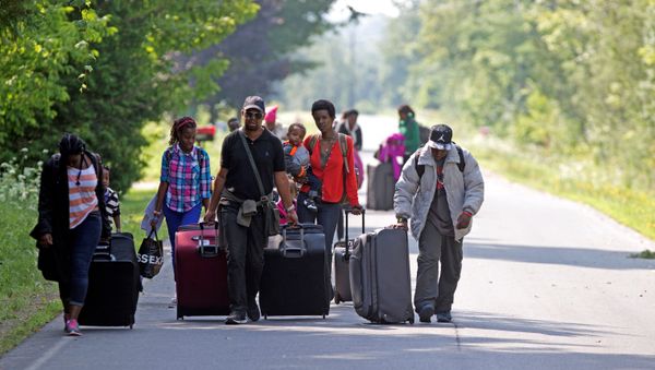 Three families that claimed to be from Burundi walk down Roxham Road to cross into Quebec at the US-Canada border in Champlain, New York,  August 3, 2017 - Sputnik International