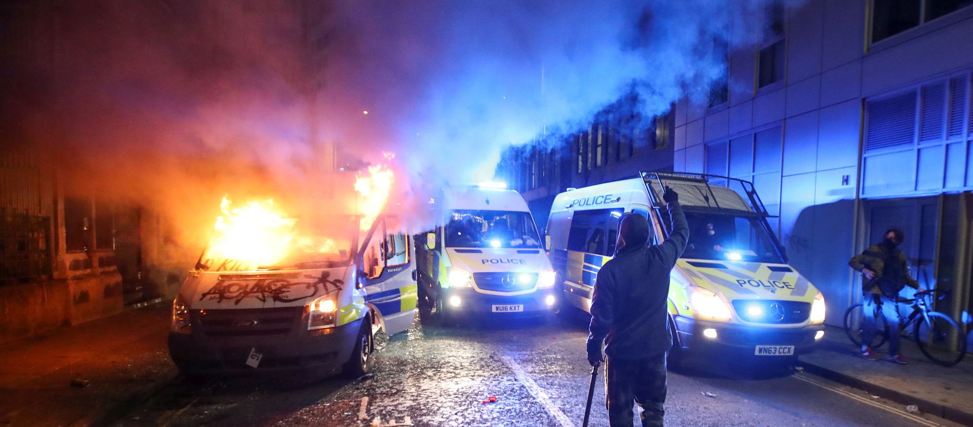 A demonstrator gestures near a burning police vehicle during a protest against a new proposed policing bill, in Bristol, Britain, March 21, 2021. A demonstrator gestures near a burning police vehicle during a protest against a new proposed policing bill, in Bristol, Britain, March 21, 2021. - Sputnik International, 1920, 23.03.2021