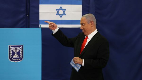 Israeli Prime Minister Benjamin Netanyahu gestures while standing near a voting booth as he prepares to cast his ballot in Israel's general election, at a polling station in Jerusalem March 23, 2021 - Sputnik International