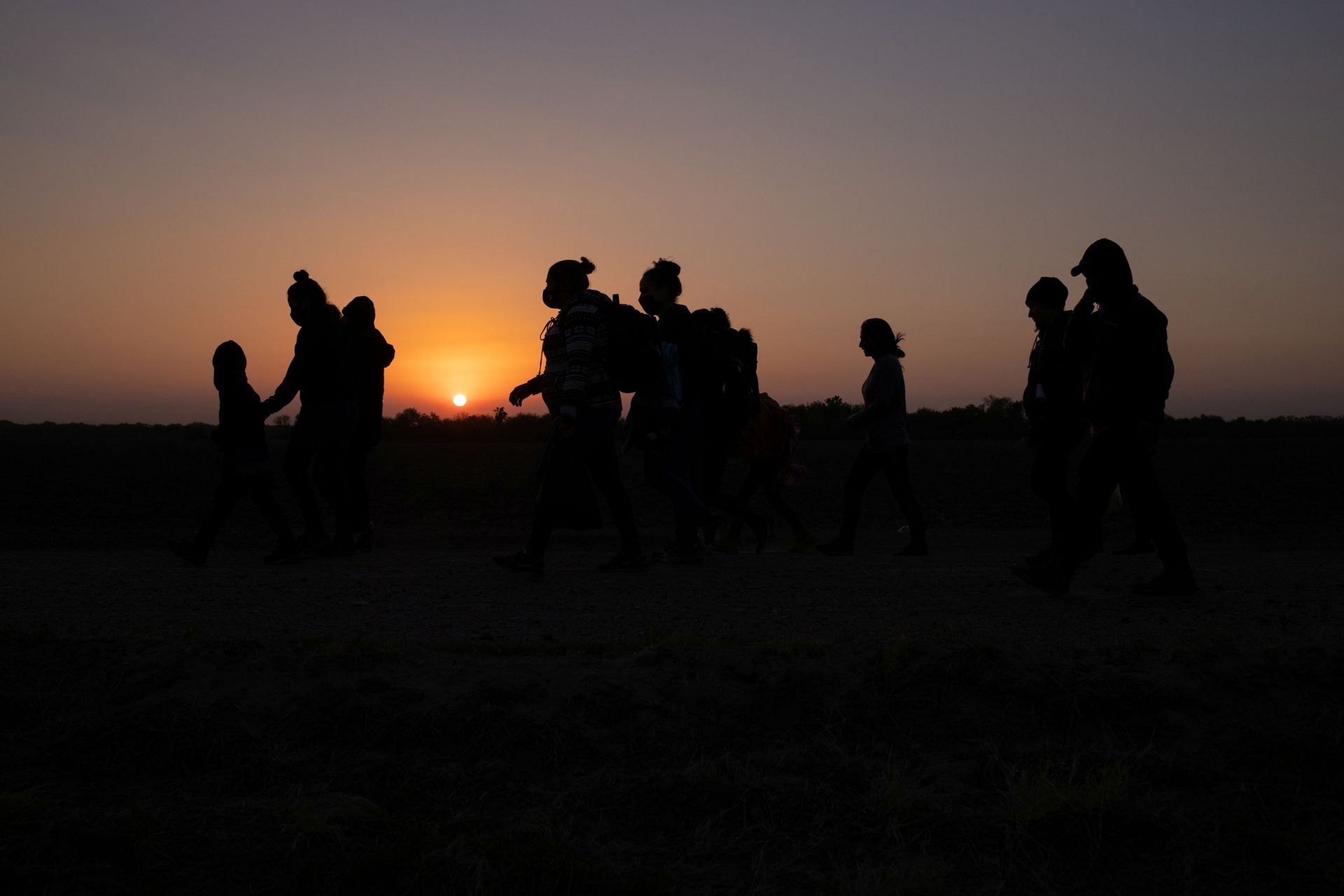 The sun rises as asylum-seeking migrants' families from Honduras and El Salvador walk towards the border wall after crossing the Rio Grande river into the United States from Mexico on a raft, in Penitas, Texas, U.S., March 26, 2021 The sun rises as asylum-seeking migrants' families from Honduras and El Salvador walk towards the border wall after crossing the Rio Grande river into the United States from Mexico on a raft, in Penitas, Texas, U.S., March 26, 2021 - Sputnik International, 1920, 07.09.2021