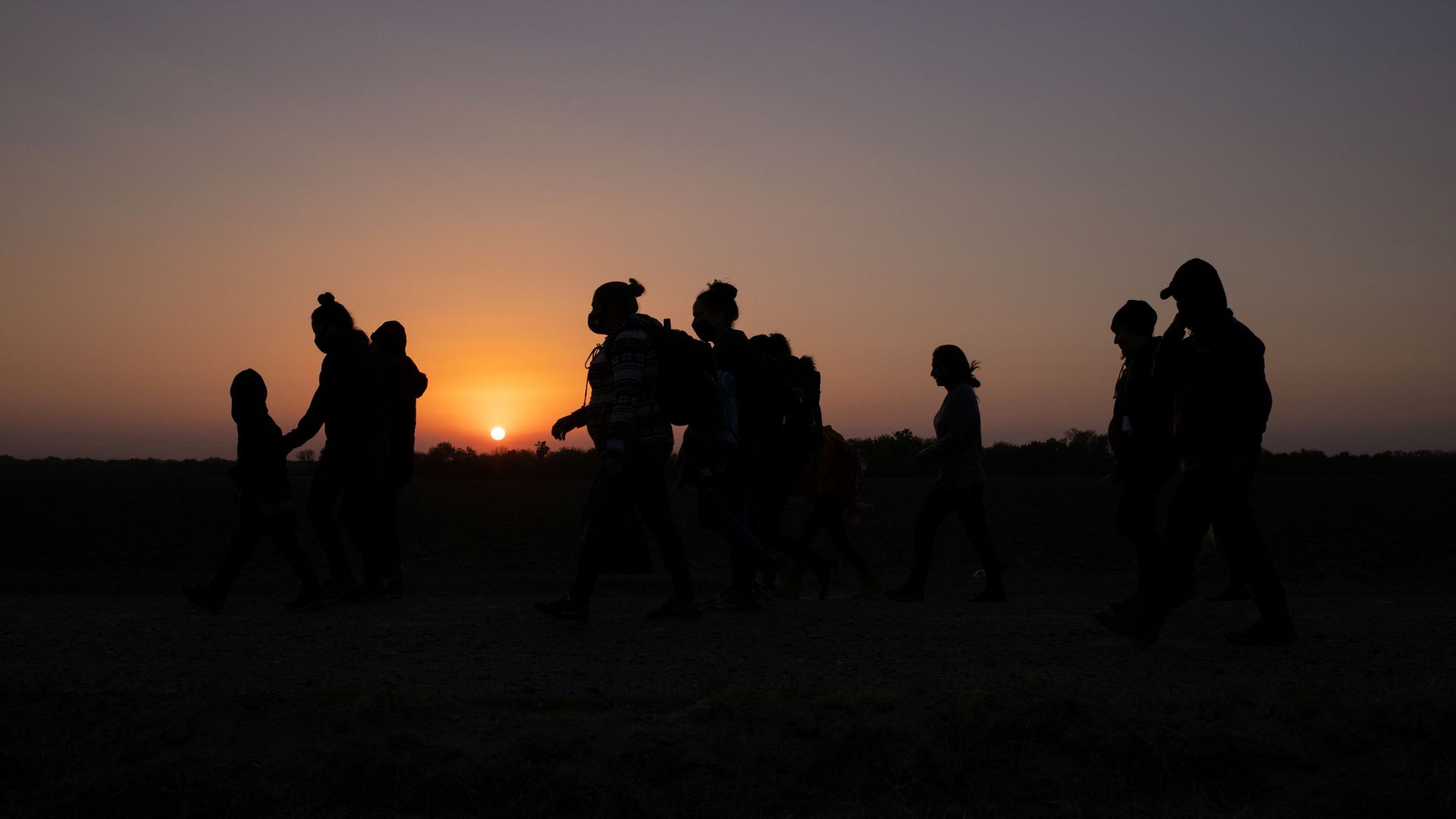 The sun rises as asylum-seeking migrants' families from Honduras and El Salvador walk towards the border wall after crossing the Rio Grande river into the United States from Mexico on a raft, in Penitas, Texas, U.S., March 26, 2021 The sun rises as asylum-seeking migrants' families from Honduras and El Salvador walk towards the border wall after crossing the Rio Grande river into the United States from Mexico on a raft, in Penitas, Texas, U.S., March 26, 2021 - Sputnik International, 1920, 26.03.2021