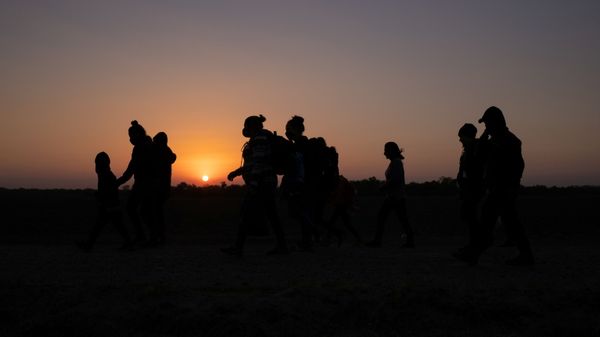 The sun rises as asylum-seeking migrants' families from Honduras and El Salvador walk towards the border wall after crossing the Rio Grande river into the United States from Mexico on a raft, in Penitas, Texas, 26 March 2021 - Sputnik International