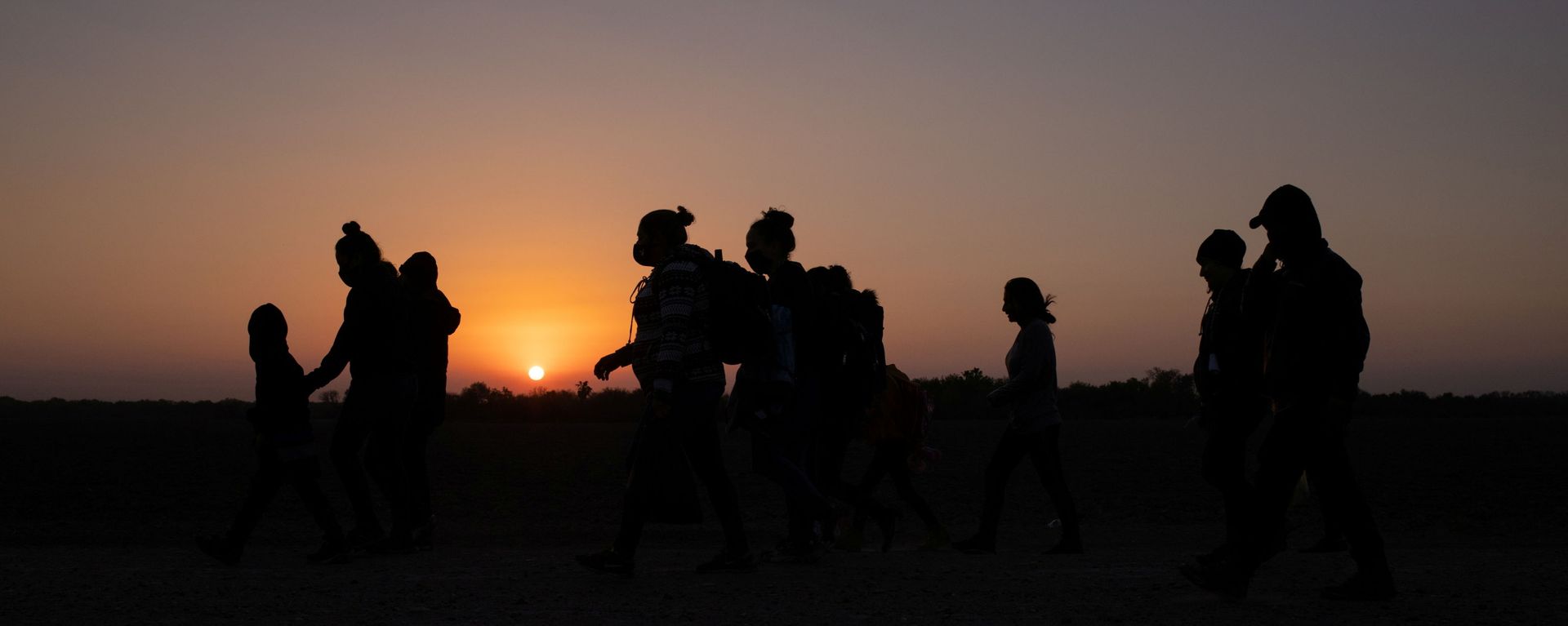 The sun rises as asylum-seeking migrants' families from Honduras and El Salvador walk towards the border wall after crossing the Rio Grande river into the United States from Mexico on a raft, in Penitas, Texas, U.S., March 26, 2021 The sun rises as asylum-seeking migrants' families from Honduras and El Salvador walk towards the border wall after crossing the Rio Grande river into the United States from Mexico on a raft, in Penitas, Texas, U.S., March 26, 2021 - Sputnik International, 1920, 26.03.2021