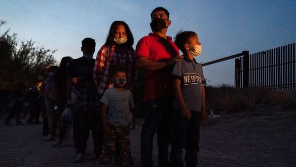 Asylum-seeking migrants' families make a line to board a bus as they wait to be transported by the U.S. Border Patrols after crossing the Rio Grande river into the United States from Mexico in Penitas, Texas, U.S., March 26, 2021. - Sputnik International