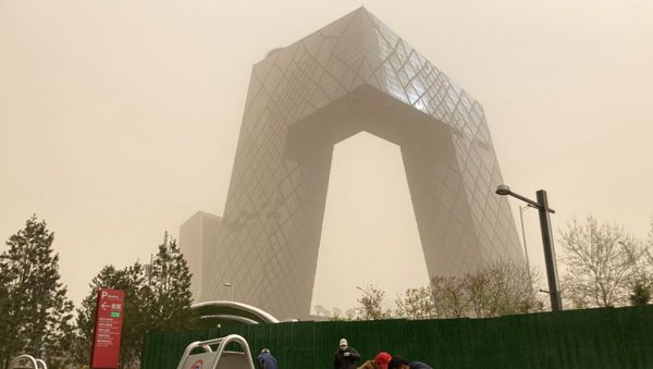 Construction workers are seen in front of the CCTV headquarters shrouded in dust as the city is hit by a sandstorm, in Beijing, China March 28, 2021. - Sputnik International
