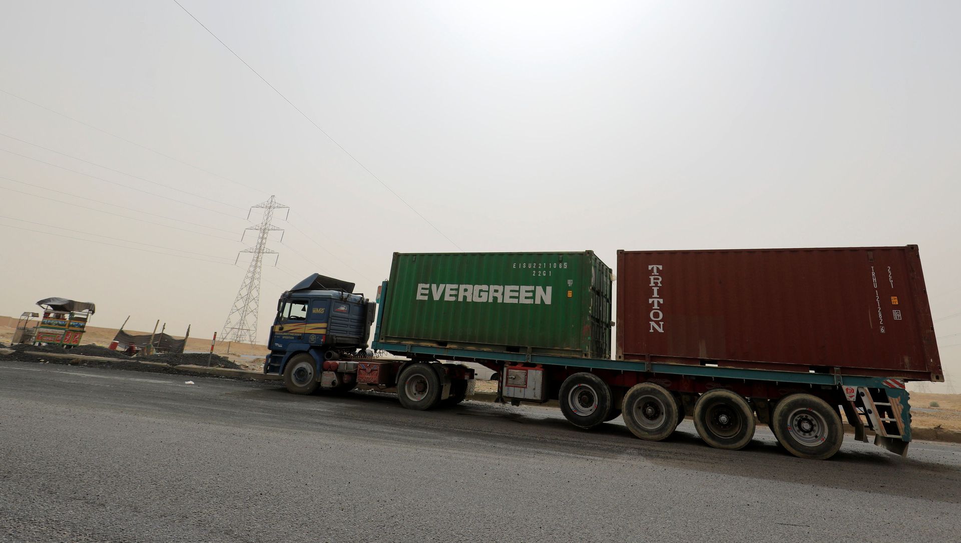 A truck carrying Evergreen and Triton containers waits to pass through the main gate of the El Ain El Sokhna port to the Suez Canal in dusty weather, 24 March 2021 A truck carrying Evergreen and Triton containers waits to pass through the main gate of the El Ain El Sokhna port to the Suez Canal in dusty weather, 24 March 2021 - Sputnik International, 1920, 29.03.2021