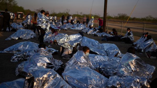 Linda, an asylum-seeking migrant from Honduras, awakes at sunrise next to others who took refuge near a baseball field after crossing the Rio Grande river into the United States from Mexico on rafts, in La Joya, Texas, U.S., March 19, 2021.  - Sputnik International
