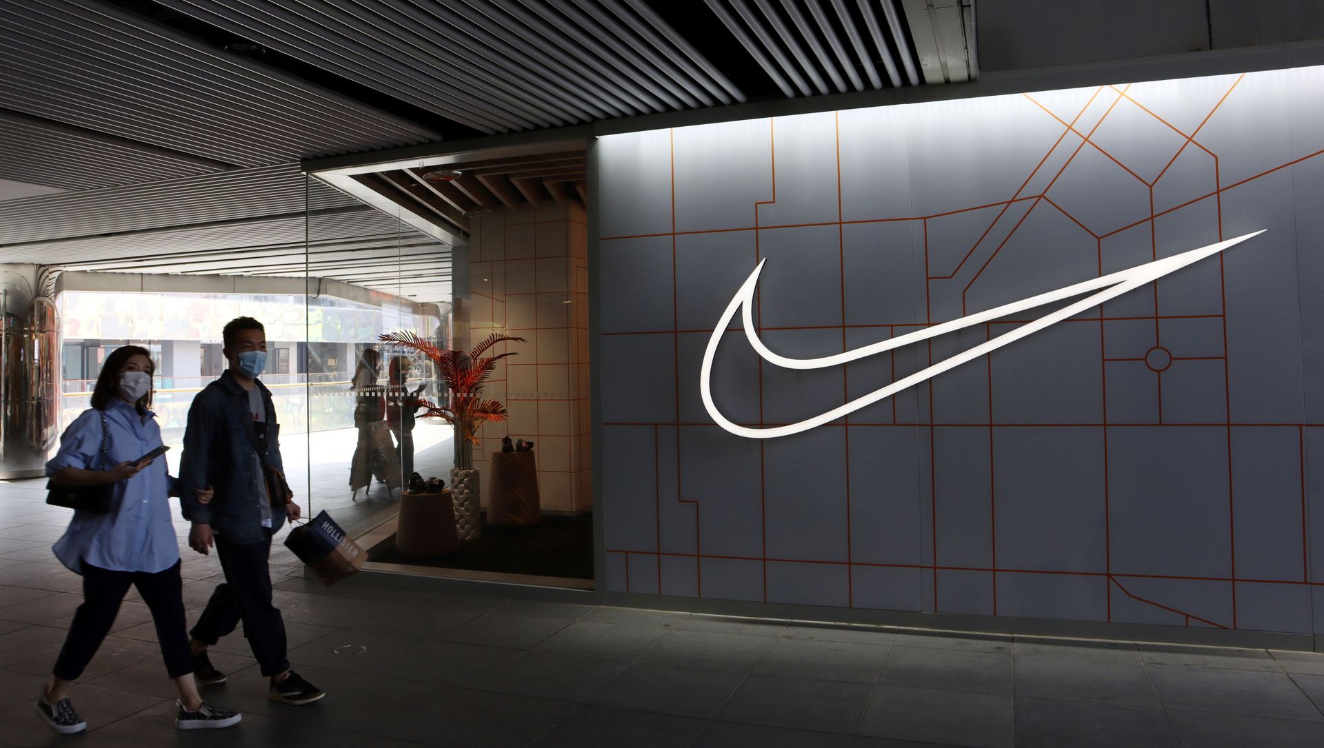 People walk past a store of the sporting goods retailer Nike Inc at a shopping complex in Beijing, China March 25, 2021 People walk past a store of the sporting goods retailer Nike Inc at a shopping complex in Beijing, China March 25, 2021 - Sputnik International, 1920, 19.05.2021