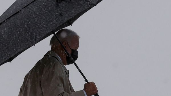U.S. President Joe Biden walks in the rain prior to boarding Air Force One as he departs Washington for travel to Pittsburgh, Pennsylvania at Joint Base Andrews, Maryland, U.S., March 31, 2021. - Sputnik International