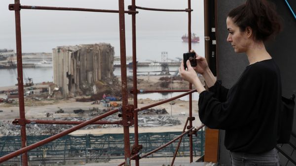 Joana Dagher, 33, who lost her memory for two full months from the trauma she suffered in the massive August explosion at the Beirut port, including a cerebral contusion and brain lesions, takes pictures of the explosion scene from her damaged apartment rooftop, in Beirut, Lebanon, Wednesday, Jan. 27, 2021. - Sputnik International