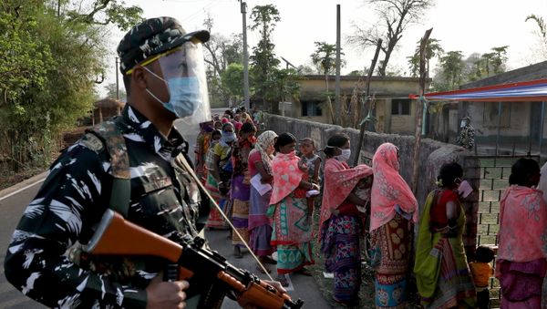 An armed policeman wearing a face shield stands guard as women wait in line to cast their votes outside a polling booth during the first phase of the West Bengal state election in Purulia district, India, March 27, 2021. An armed policeman wearing a face shield stands guard as women wait in line to cast their votes outside a polling booth during the first phase of the West Bengal state election in Purulia district, India, March 27, 2021. - Sputnik International
