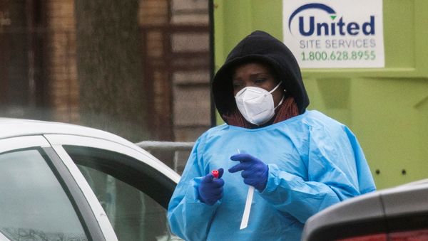 A health worker prepares to do a coronavirus disease (COVID-19) test as people wait at a drive-through COVID-19 testing center in a local street, in Newark, New Jersey, U.S - Sputnik International