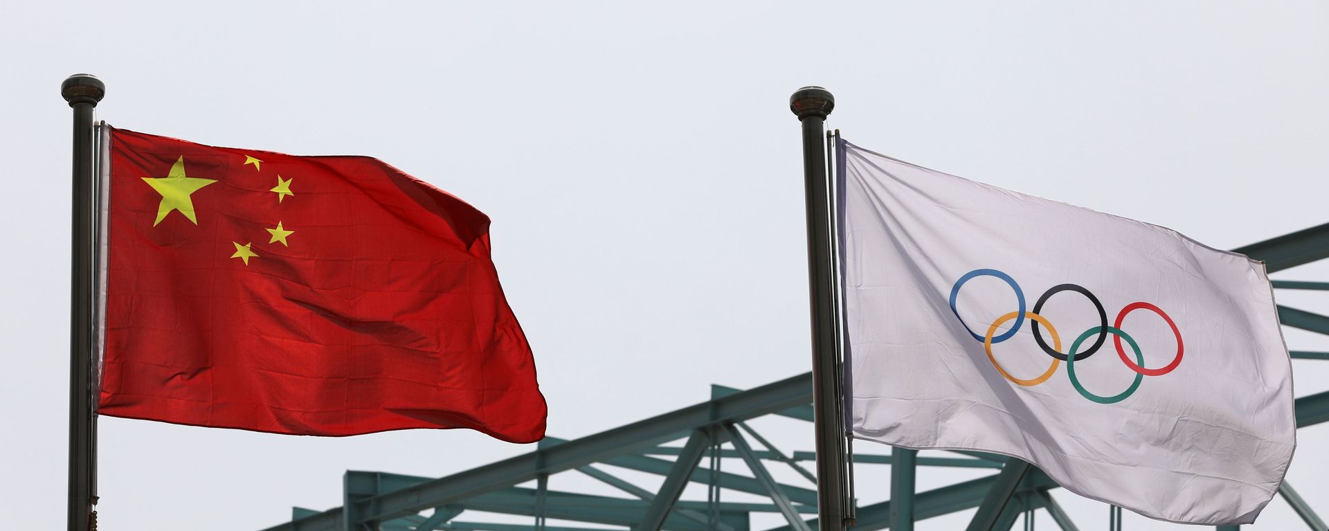 A Chinese national flag flutters next to an Olympic flag at the Beijing Organising Committee for the 2022 Olympic and Paralympic Winter Games, in Beijing, China March 30, 2021 - Sputnik International, 1920, 13.12.2021