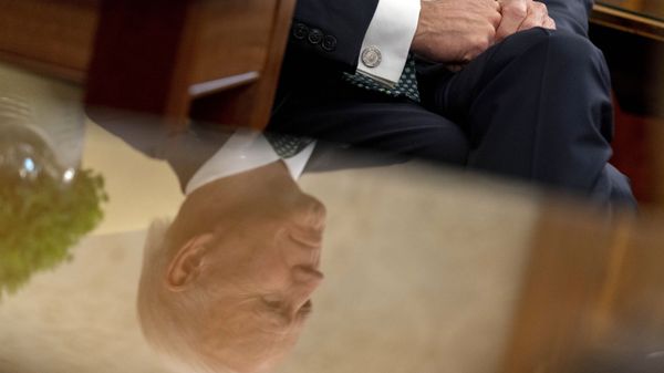 President Joe Biden, seen in reflection, sits next to a bowl of Irish shamrocks, left, as he has a virtual meeting with Ireland's Prime Minister Micheal Martin on St. Patrick's Day, in the Oval Office of the White House, Wednesday, March 17, 2021, in Washington.  - Sputnik International