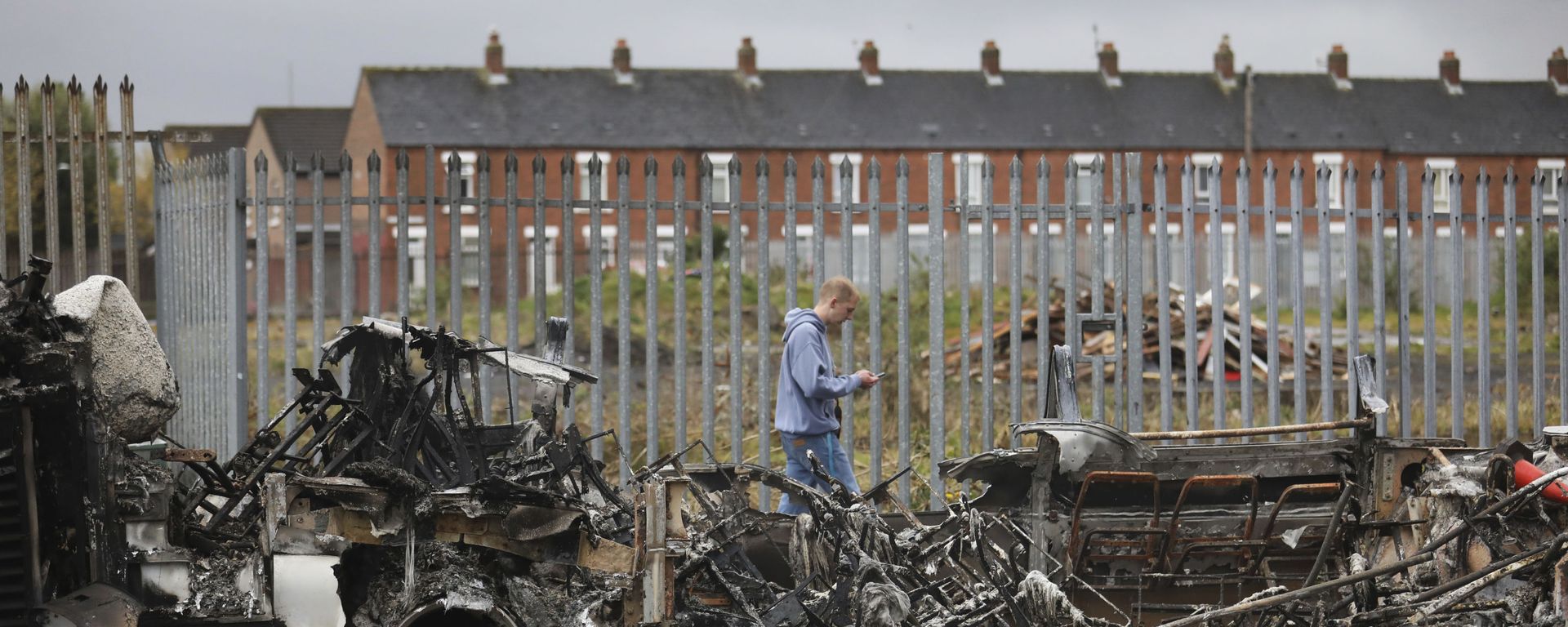 A man walks past a burnt out bus near the loyalist Shankill Road in west Belfast. - Sputnik International, 1920, 09.04.2021