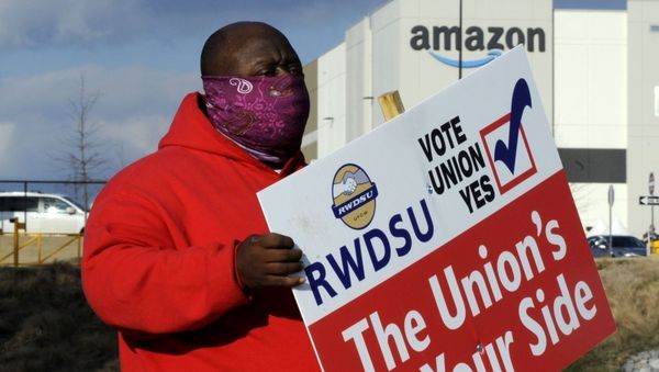 FILE - In this Tuesday, Feb. 9, 2021, file photo, Michael Foster of the Retail, Wholesale and Department Store Union holds a sign outside an Amazon facility where labor is trying to organize workers in Bessemer, Ala. - Sputnik International