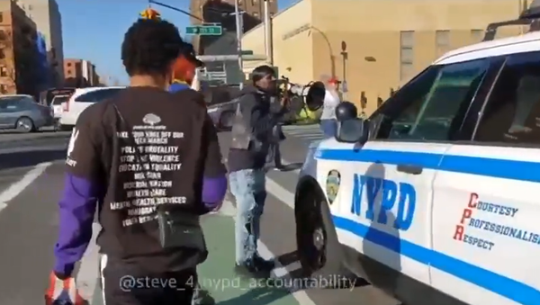 Screenshot from a video showing a group of men harassing New York Police Department officers who are driving by in an SUV - Sputnik International