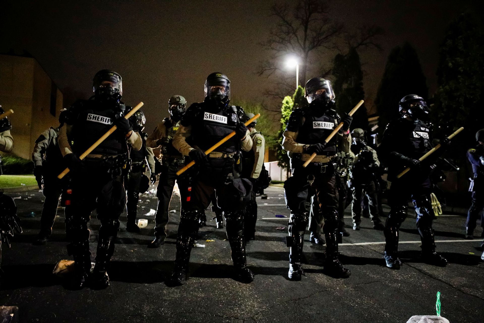 Officers stand guard outside Brooklyn Center Police Department with trash thrown at them by demonstrators at their feet after police allegedly shot and killed a man, who local media report is identified by the victim's mother as Daunte Wright, in Brooklyn Center, Minnesota, U.S., April 11, 2021.  - Sputnik International, 1920, 02.11.2021
