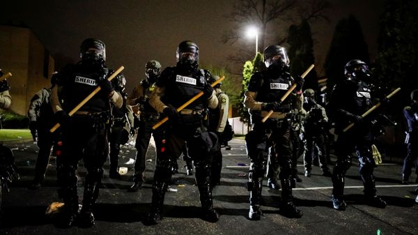 Officers stand guard outside Brooklyn Center Police Department with trash thrown at them by demonstrators at their feet after police allegedly shot and killed a man, who local media report is identified by the victim's mother as Daunte Wright, in Brooklyn Center, Minnesota, U.S., April 11, 2021.  - Sputnik International