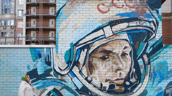 A woman walks past a mural depicting cosmonaut Yuri Gagarin in Krasnogorsk, Moscow region, Russia April 11, 2021. - Sputnik International