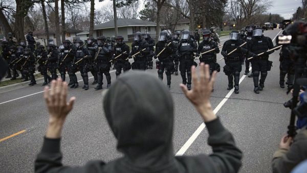 A person raises their hands as police approach near the site where a family said a man was shot and killed by local law enforcement, Sunday, April 11, 2021, in Brooklyn Center, Minn. - Sputnik International