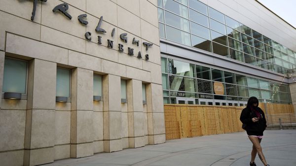 A pedestrian walks past the boarded up and closed ArcLight Cinemas Hollywood, Monday, April 12, 2021, in Los Angeles. Pacific Theaters, which operates some 300 screens in California, including the beloved ArcLight theaters and the historic Cinerama Dome in Hollywood, said Monday that it will not be reopening. Fans, including numerous actors, took to social media to share memories of the theater chain and lobby for it to be saved. - Sputnik International