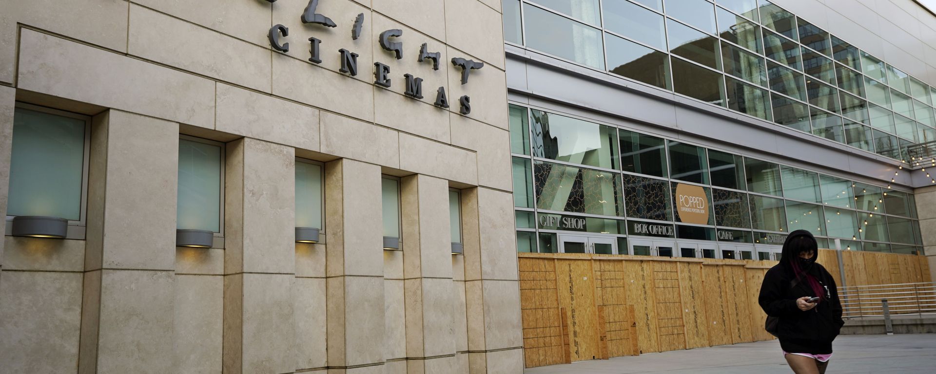 A pedestrian walks past the boarded up and closed ArcLight Cinemas Hollywood, Monday, April 12, 2021, in Los Angeles. Pacific Theaters, which operates some 300 screens in California, including the beloved ArcLight theaters and the historic Cinerama Dome in Hollywood, said Monday that it will not be reopening. Fans, including numerous actors, took to social media to share memories of the theater chain and lobby for it to be saved. - Sputnik International, 1920, 14.04.2021