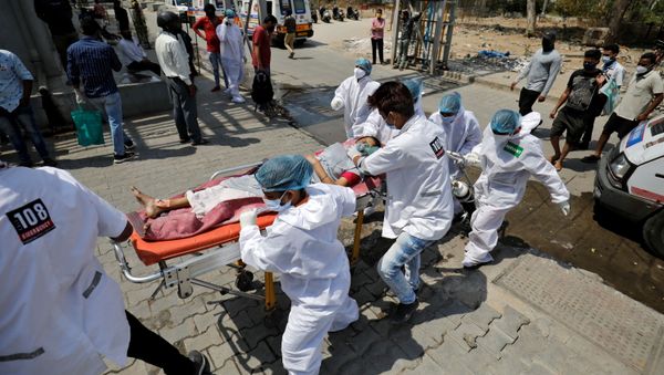 A patient with breathing problems is wheeled inside a COVID-19 hospital for treatment, amidst the coronavirus disease pandemic, Ahmedabad, India, April 14, 2021 - Sputnik International