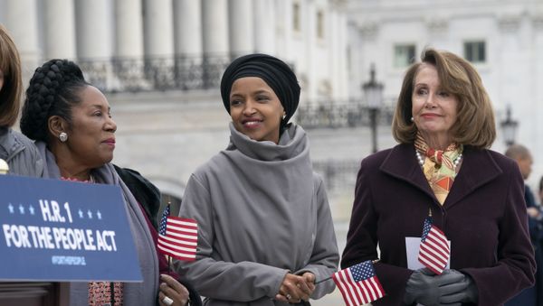 Rep. Ilhan Omar, D-Minn., smiles as she stands between Rep. Sheila Jackson Lee, D-Texas, left, and Speaker of the House Nancy Pelosi, D-Calif., as Democrats rally outside the Capitol ahead of passage of H.R. 1, The For the People Act, a bill which aims to expand voting rights and strengthen ethics rules, in Washington, Friday, March 8, 2019. - Sputnik International