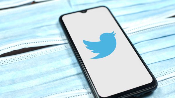 Twitter logo on smartphone screen over the face masks - Sputnik International