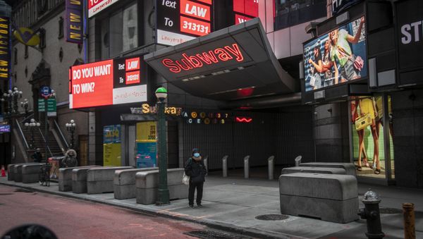 A woman stands alone outside an empty subway entrance on 42nd Street in Times Square, which is usually bustling with activity, in New York, on Wednesday, March 25, 2020.  - Sputnik International