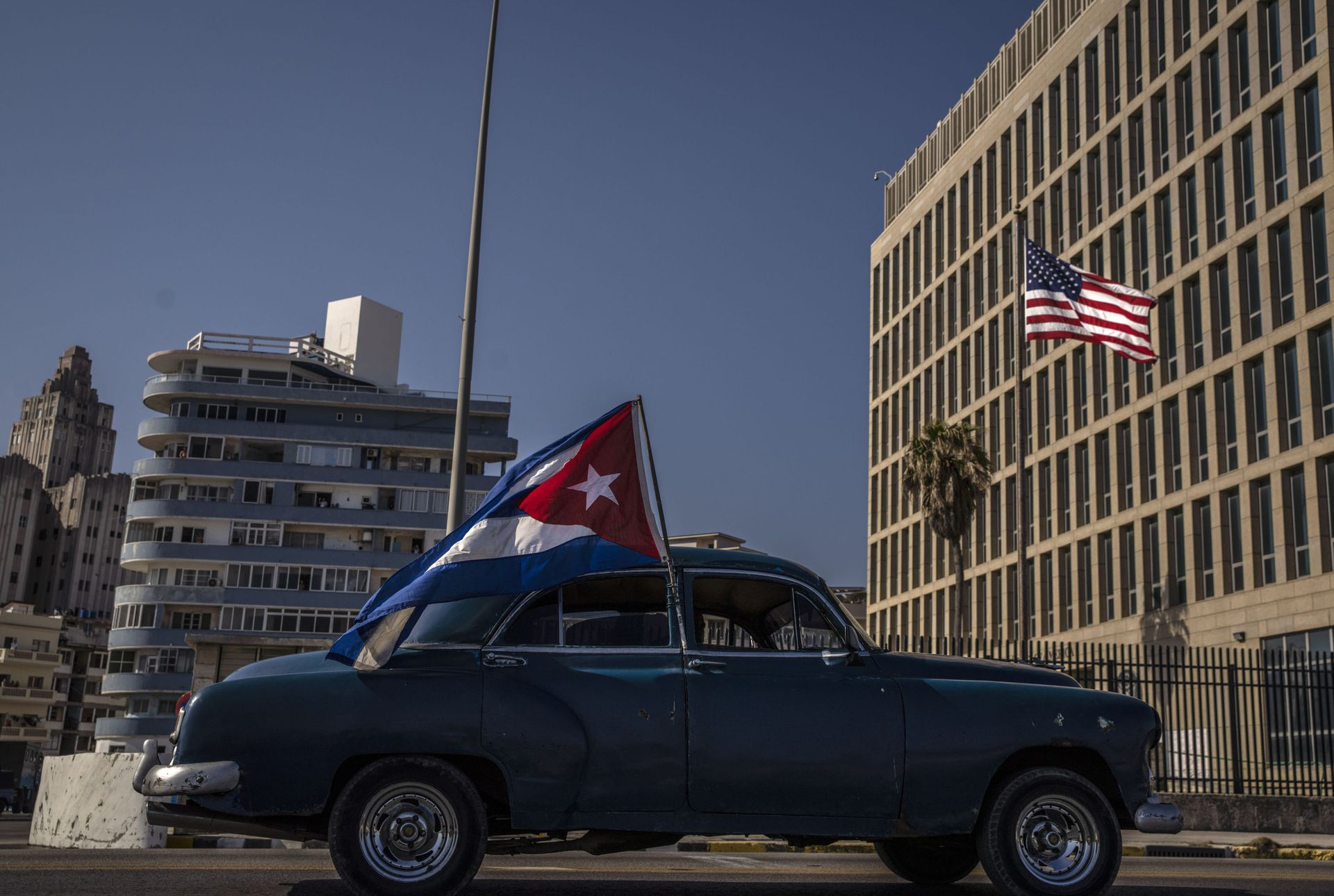 A classic American car flying a Cuban flag drives past the American embassy during a rally calling for the end of the US blockade against the island nation, in Havana, Cuba, Sunday, March 28, 2021. A classic American car flying a Cuban flag drives past the American embassy during a rally calling for the end of the US blockade against the island nation, in Havana, Cuba, Sunday, March 28, 2021. - Sputnik International, 1920, 09.08.2022