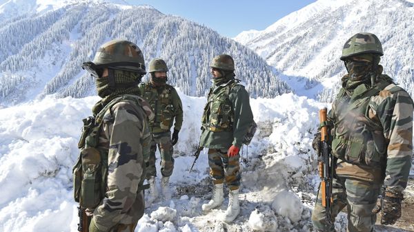 Indian army soldiers stand on a snow-covered road near Zojila mountain pass that connects Srinagar to the union territory of Ladakh, bordering China on February 28, 2021.  - Sputnik International