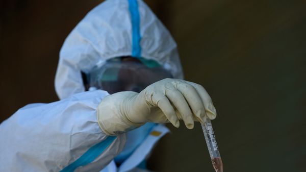 A doctor wearing a hazmat suit holds a tube containig a sample for testing the COVID-19 coronavirus during a government-imposed nationwide lockdown as a preventive measure against the COVID-19 coronavirus, in Srinagar on April 30, 2020.  - Sputnik International