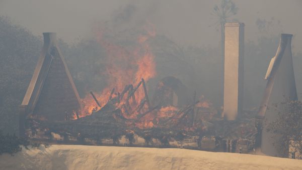 This picture taken in Cape Town on April 18, 2021 shows a historical Cape Dutch building burning after catching alight as a forest fire burns out of control on the foothills of Table Mountain, above the University of Cape Town. - Sputnik International