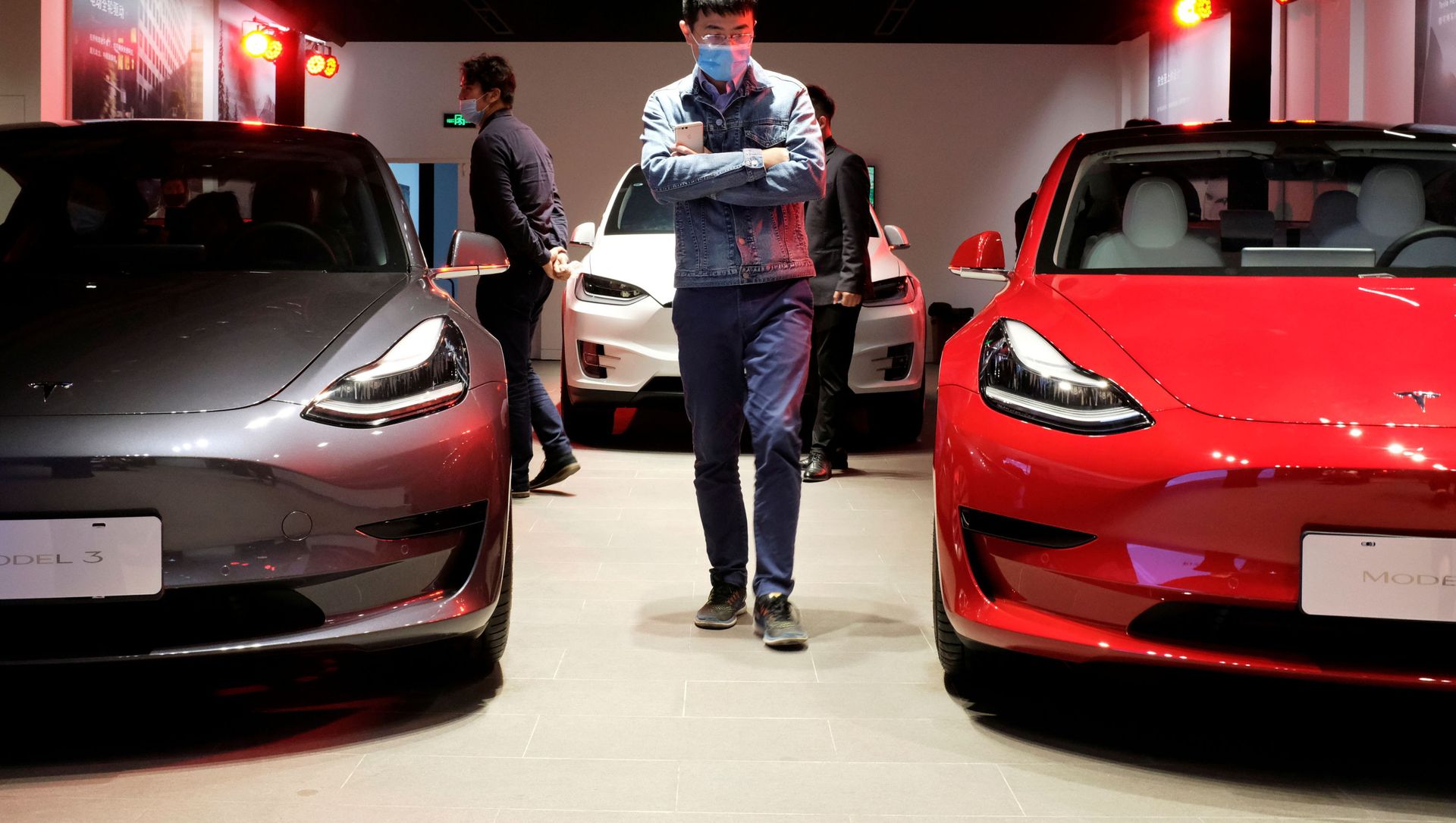 A man wearing a face mask following the coronavirus disease (COVID-19) outbreak walks by Tesla Model 3 sedans and Tesla Model X sport utility vehicle at a new Tesla showroom in Shanghai, China May 8, 2020. A man wearing a face mask following the coronavirus disease (COVID-19) outbreak walks by Tesla Model 3 sedans and Tesla Model X sport utility vehicle at a new Tesla showroom in Shanghai, China May 8, 2020. - Sputnik International, 1920, 19.04.2021