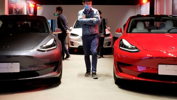 A man wearing a face mask following the coronavirus disease (COVID-19) outbreak walks by Tesla Model 3 sedans and Tesla Model X sport utility vehicle at a new Tesla showroom in Shanghai, China May 8, 2020. - Sputnik International